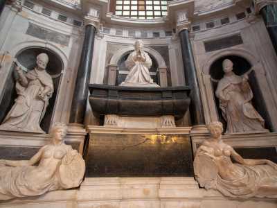 Alle sue spalle, non meno imponente, ammiriamo il monumento sepolcrale di Bona Sforza, realizzato a Napoli fra il 1589 e il 1595, innalzato in memoria della duchessa di Bari di cui ospita le spoglie. La Sforza � qui rappresentata da una statua di marmo bianco immacolato mentre � in ginocchio e con le mani giunte in atto di preghiera. Su di lei vegliano San Stanislao e San Nicola